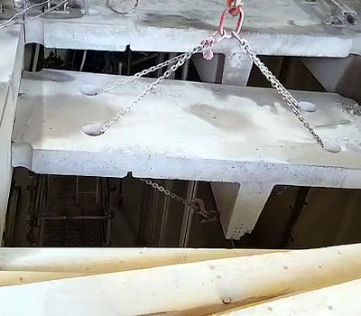 Ein abgeschnittenes Betonsegment wird mit dem Portalkran abgelassen